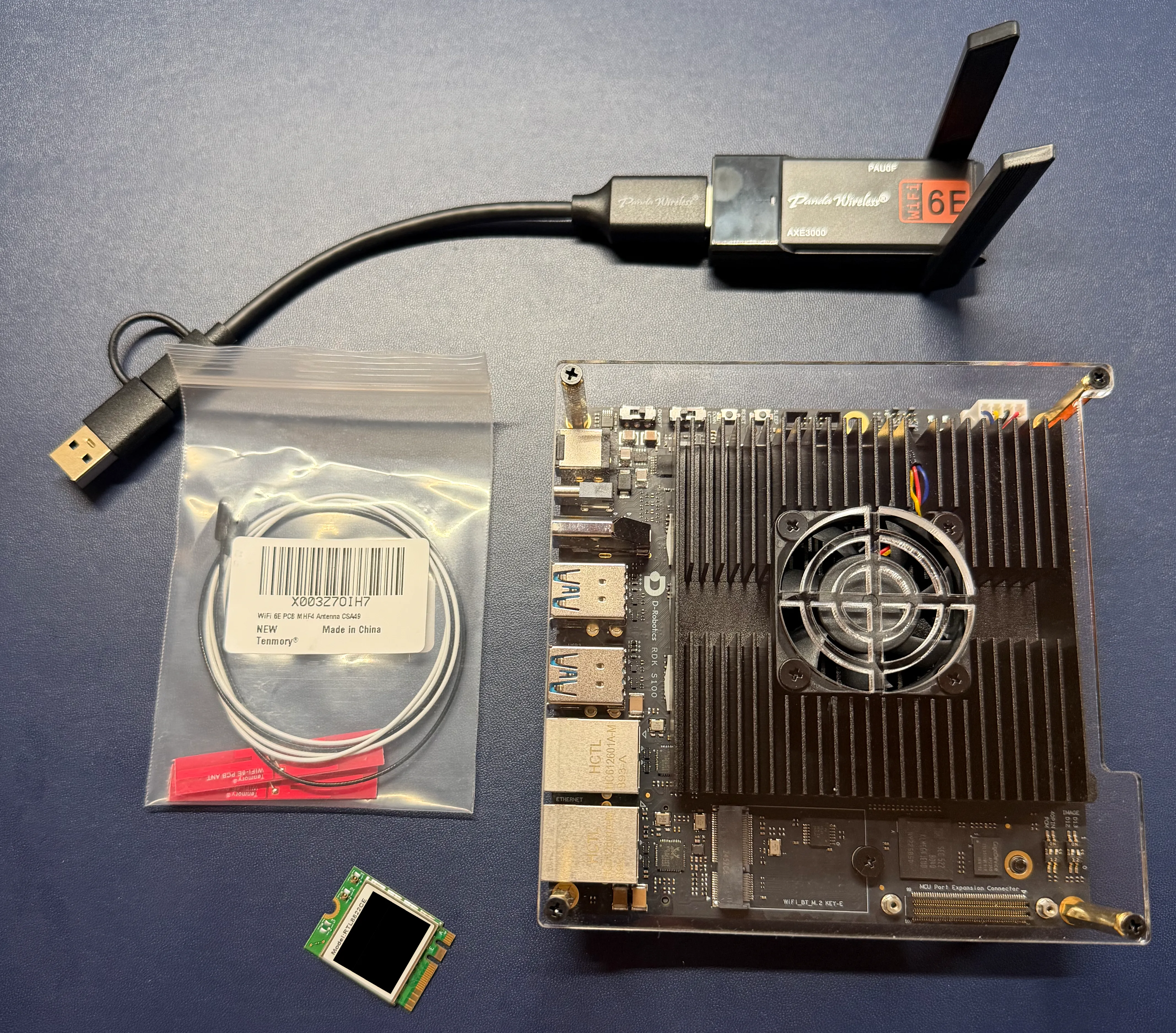 Photo of the S100P next to the M.2 card and Wi-Fi USB adapter.